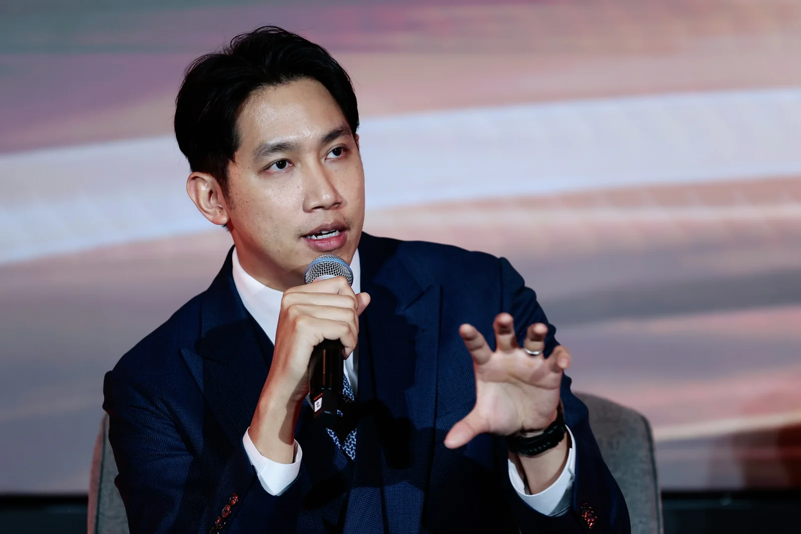 A speaker responding during a seated conversation.