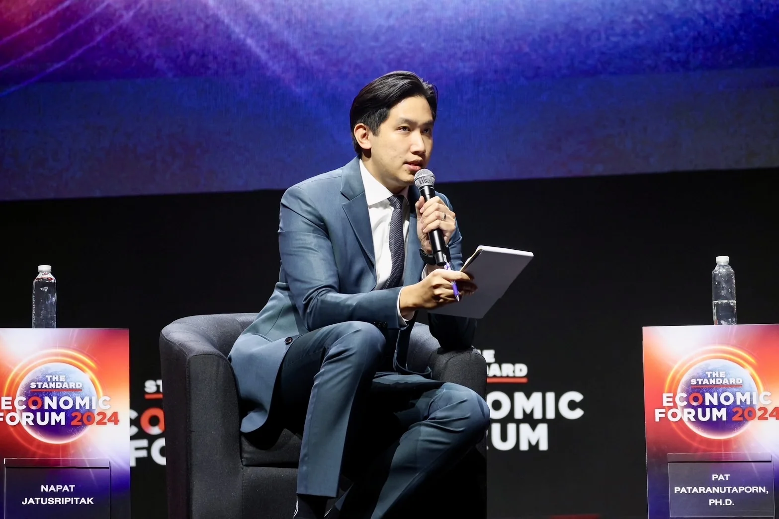 A speaker in a panel conversation at an economic forum.