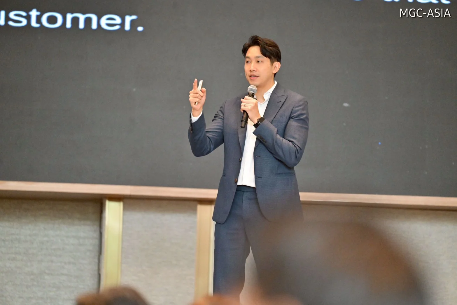 A speaker addressing an audience during a business presentation.