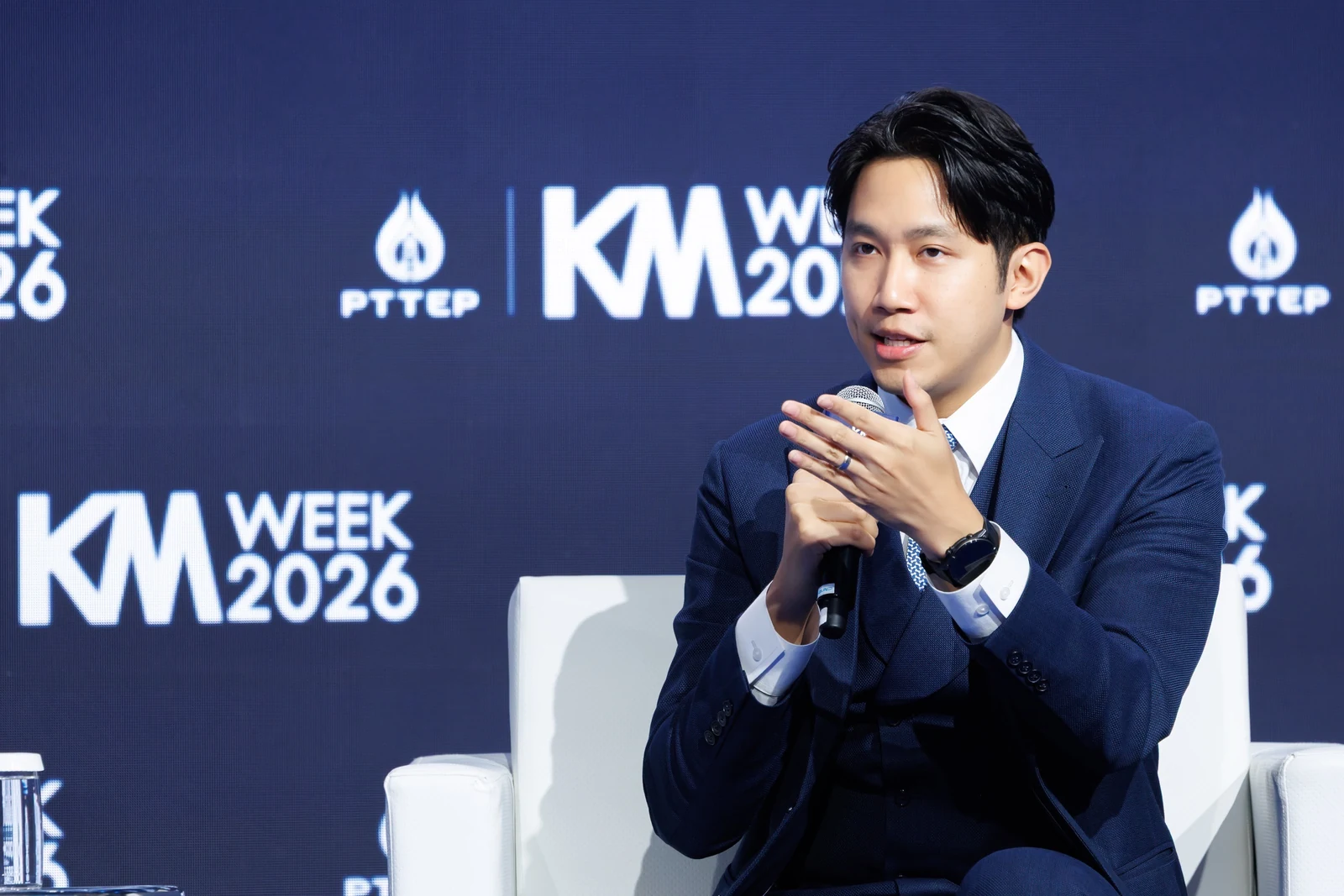 A speaker in conversation against the PTTEP KM Week 2026 backdrop.