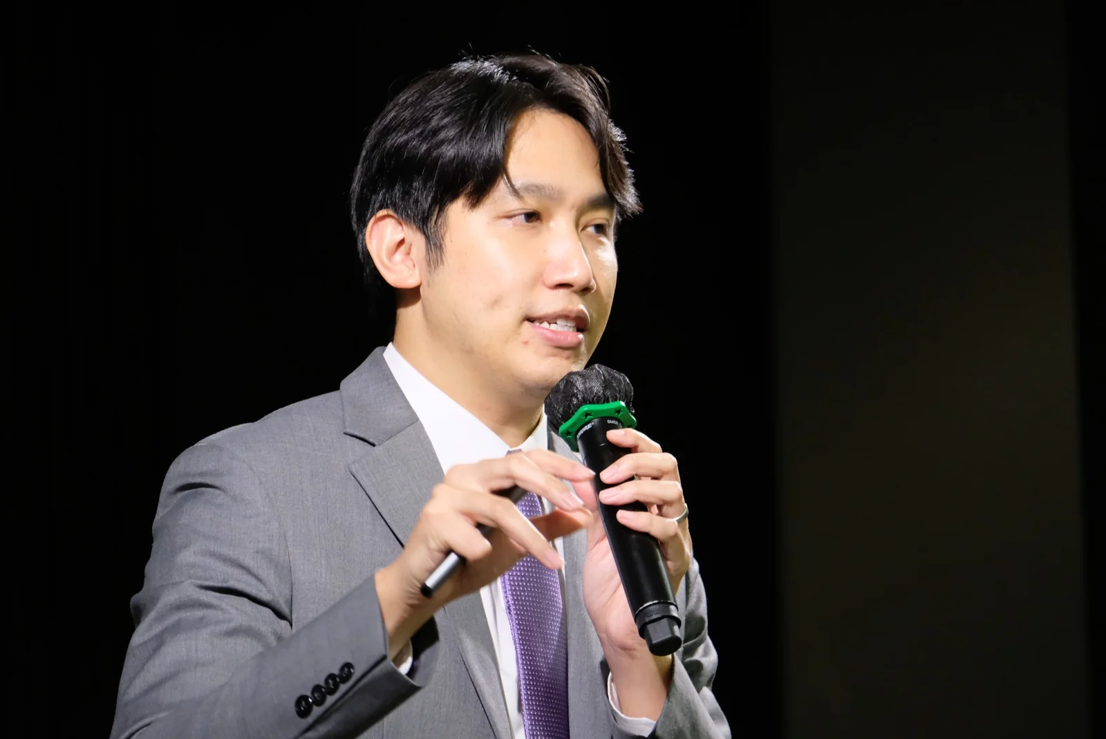 A speaker responding with a handheld microphone.